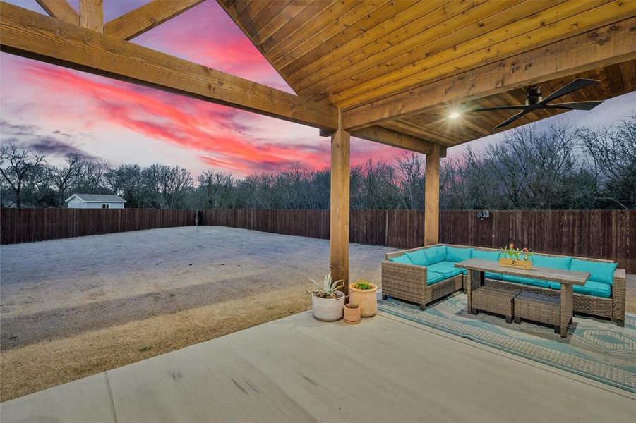 Patio terrace at dusk with outdoor lounge area, a fenced backyard, a ceiling fan, and a patio area