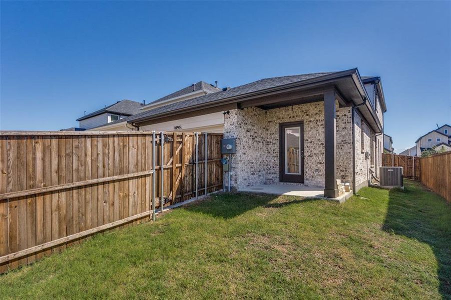 Back of house with a patio, brick siding, a fenced backyard, and a shingled roof Back of house with a patio, brick siding, a fenced backyard, and a shingled roof