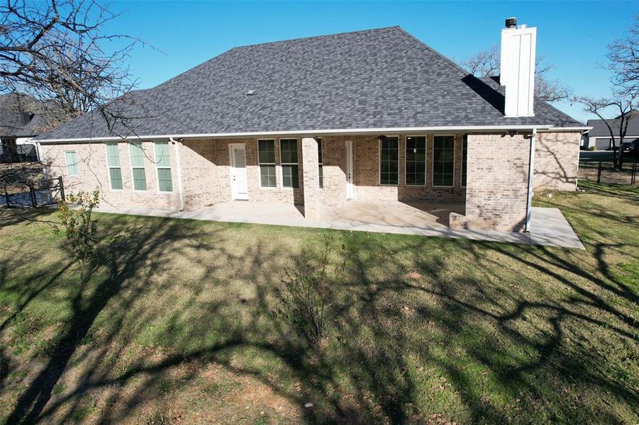 Rear view of house featuring a lawn and a patio area