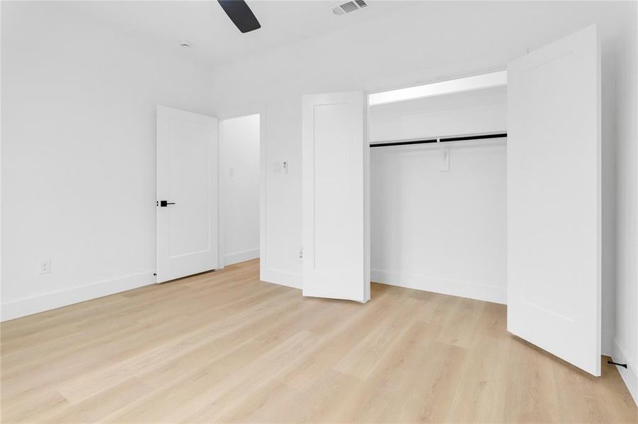 Unfurnished bedroom featuring light wood-style flooring, ceiling fan, and a closet