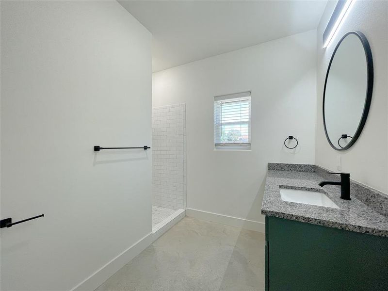 Bathroom featuring vanity and a tile shower