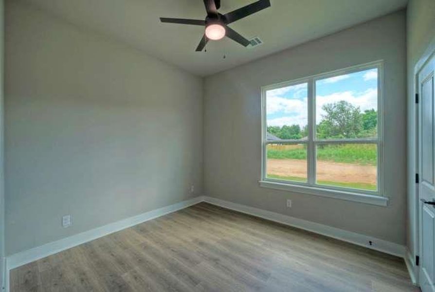 A quiet space with rich hardwood flooring and a broad window providing ample natural illumination.