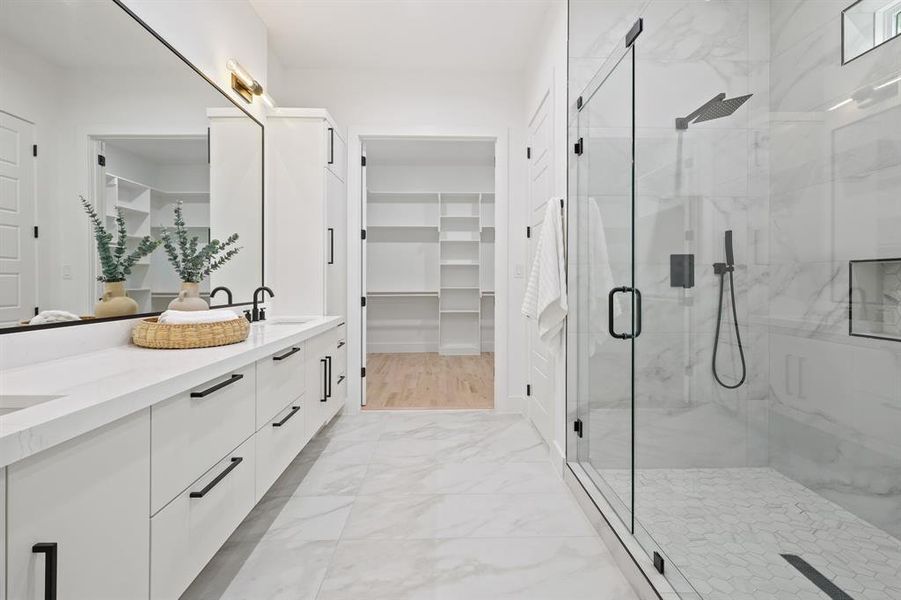 Bathroom featuring an enclosed shower, dual bowl vanity, and hardwood / wood-style floors