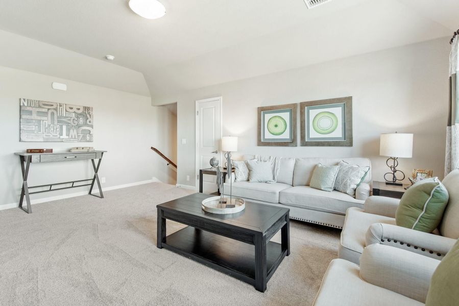 Upstairs living room with white sofa, dark wood coffee table, and neutral carpet near staircase Upstairs living room with white sofa, dark wood coffee table, and neutral carpet near staircase