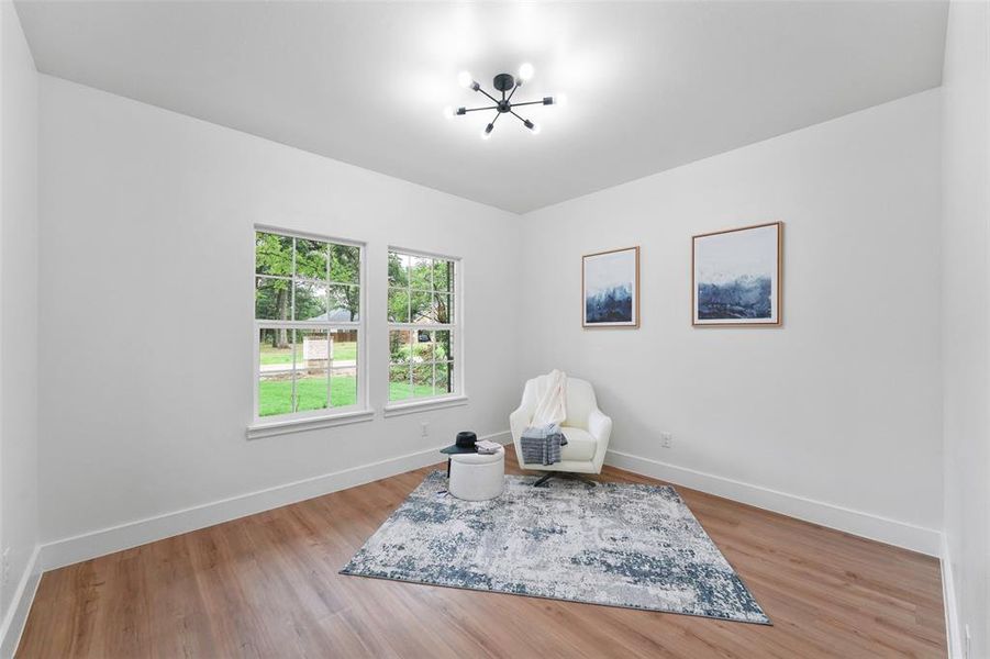 Bright room with wood-finish flooring and white baseboards Bright room with wood-finish flooring and white baseboards
