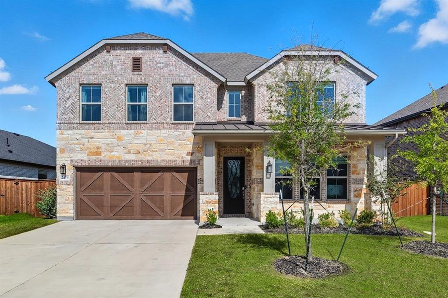 View of front of home featuring stone siding, driveway, an attached garage, and brick siding View of front of home featuring stone siding, driveway, an attached garage, and brick siding