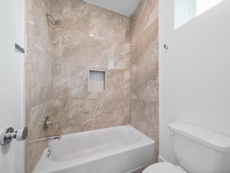 Experience luxury and elegance in this beautifully designed bathroom, featuring sleek marble tiles and modern fixtures, representative of the community's sophisticated style.Photo Disclaimer: Photos are representative of the community and may depict a similar floor plan, model home, or previously completed residence.