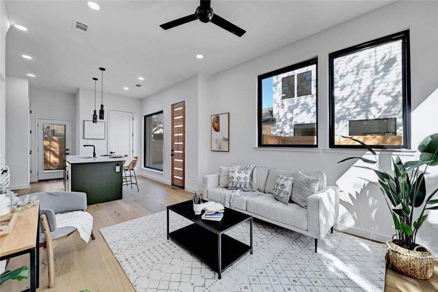 Living room featuring healthy amount of natural light, light wood-style flooring, recessed lighting, and a ceiling fan