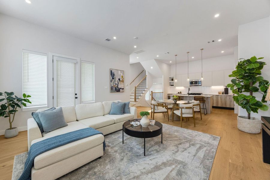 Open-concept living and dining space filled with natural light, high ceilings, modern finishes, and seamless entertaining flow.