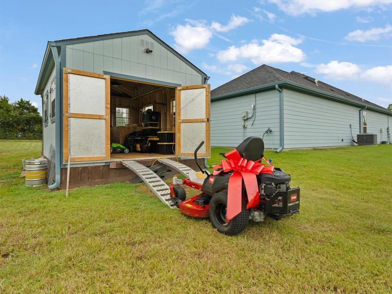 Back of Shed opens with ramp for riding lawn mower.