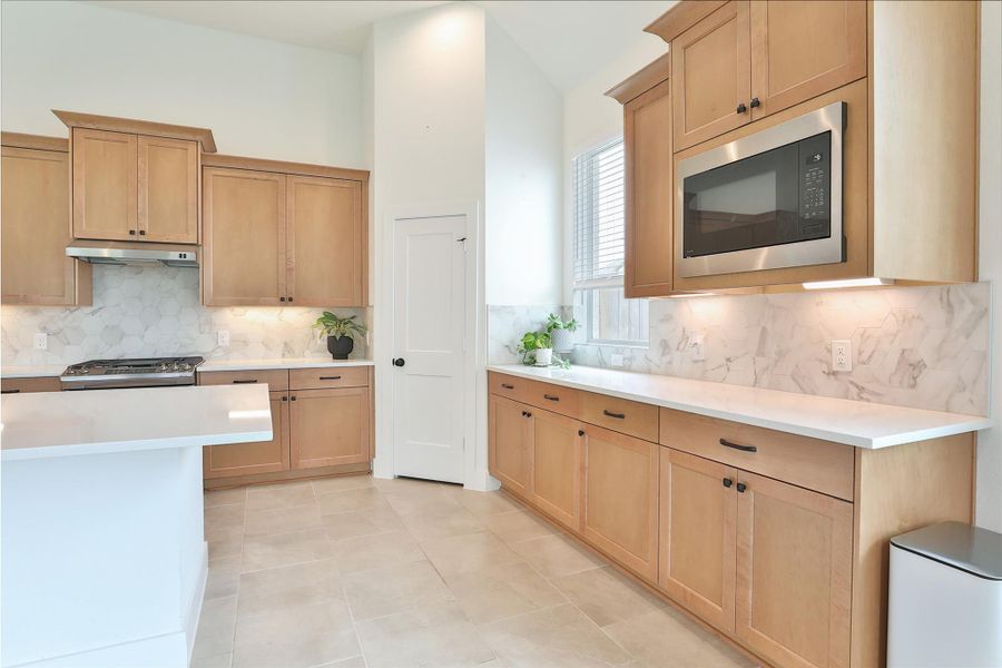 Ample countertop space complemented by the upgraded J-Kraft cabinetry, showcasing elegant details throughout the kitchen. Ample countertop space complemented by the upgraded J-Kraft cabinetry, showcasing elegant details throughout the kitchen.