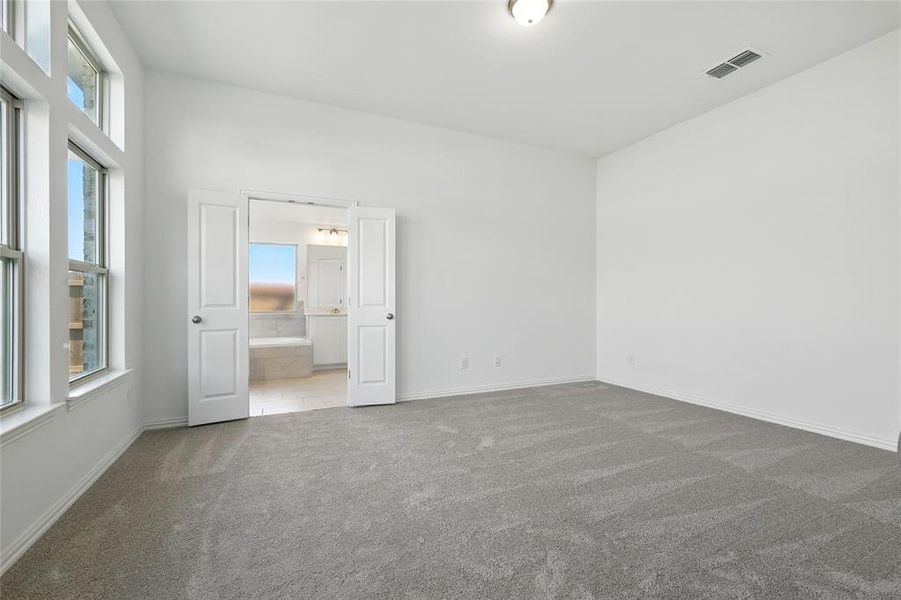 Spare room with dark colored carpet and baseboards