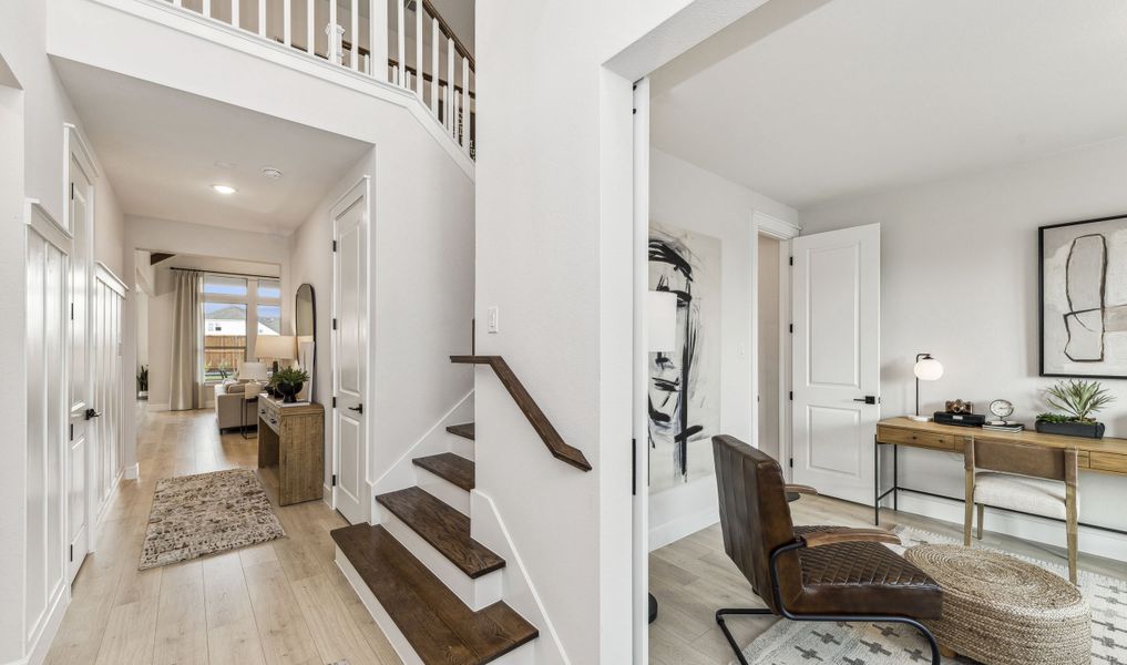 Welcoming foyer with waterfall stairs and private home office