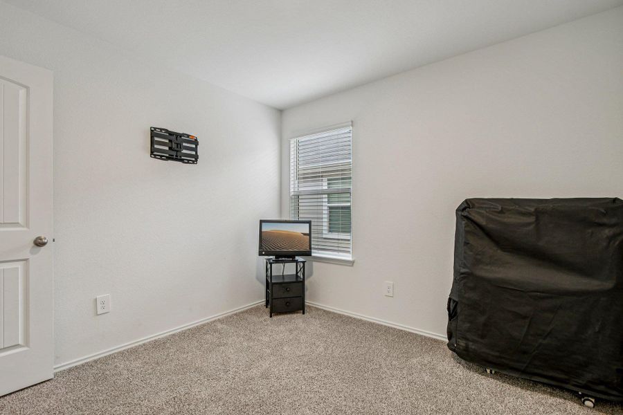 Bedroom featuring carpet and baseboards