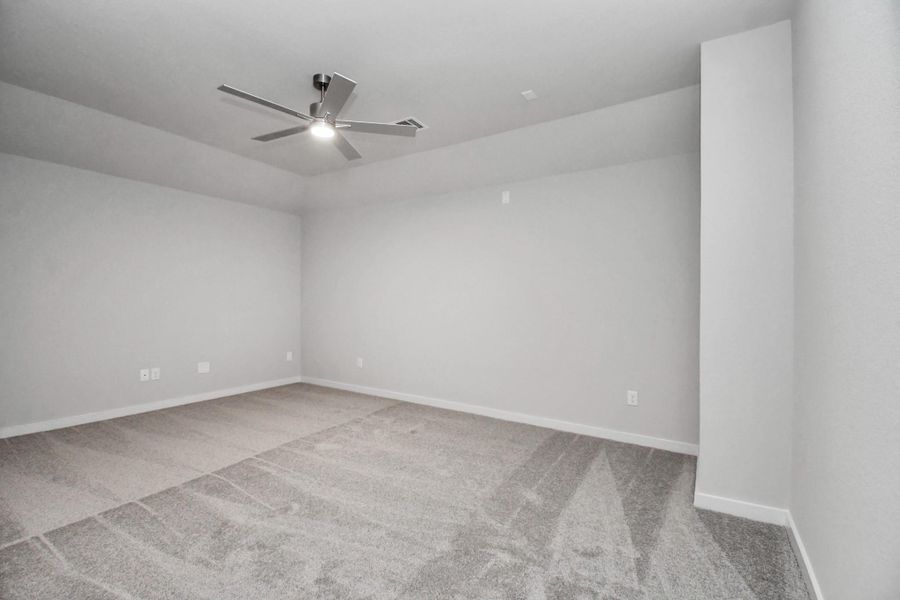 Escape to tranquility in this spacious primary room, adorned with plush carpeting and bathed in the soothing hues of warm paint colors, creating a cozy retreat for relaxation. Sample photo of completed home with similar floor plan. Actual colors and selections may vary.