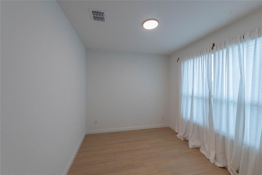 Spare room with light wood-style flooring and baseboards