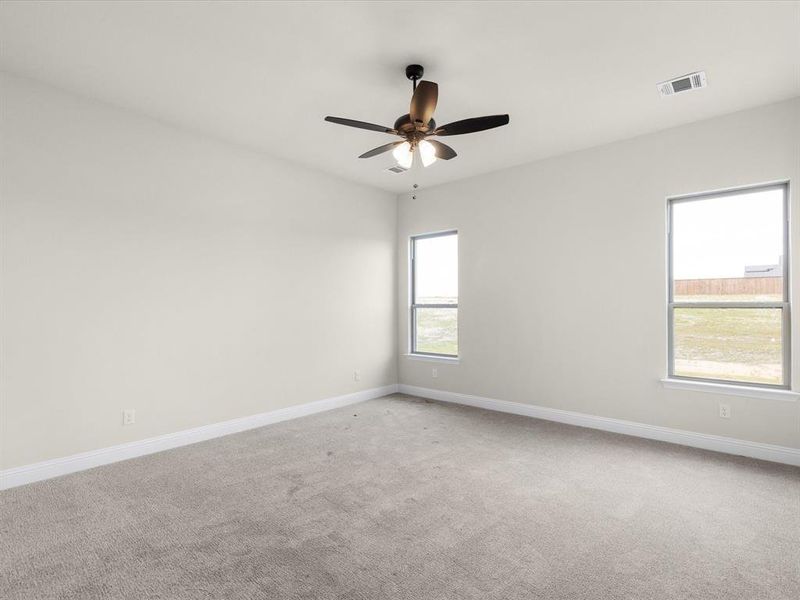 Empty room featuring light carpet and a ceiling fan