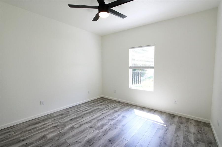 Empty room featuring wood finished floors and a ceiling fan Empty room featuring wood finished floors and a ceiling fan