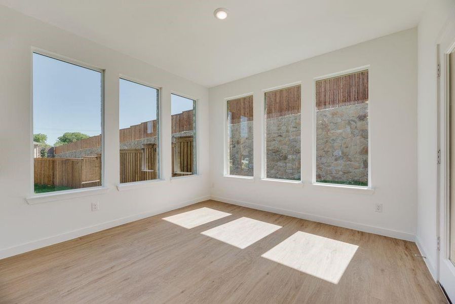 Unfurnished sunroom featuring wood finished floors and baseboards