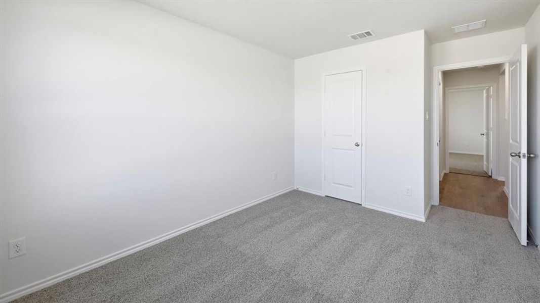 Unfurnished bedroom with carpet flooring and baseboards Unfurnished bedroom with carpet flooring and baseboards