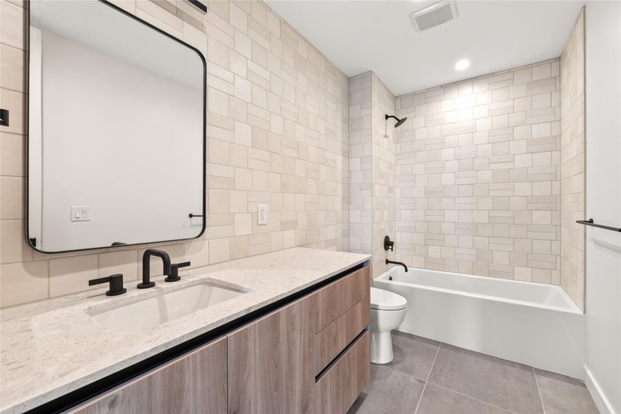 Representative of unit. Full bathroom featuring ensuite bath, bathtub, recessed lighting, and dark tile patterned floors