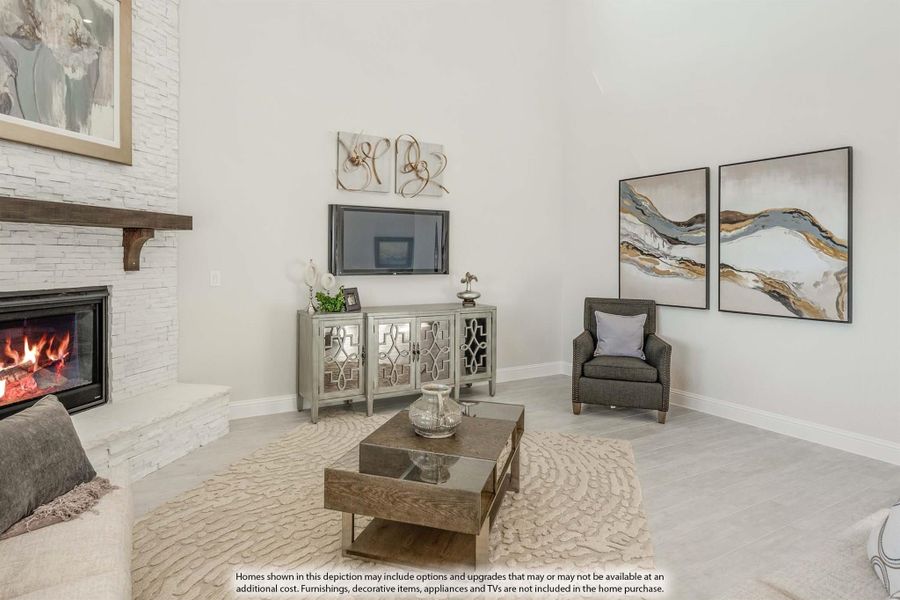 Living room with vaulted ceiling, white stone fireplace, wood coffee table, and light hardwood floors