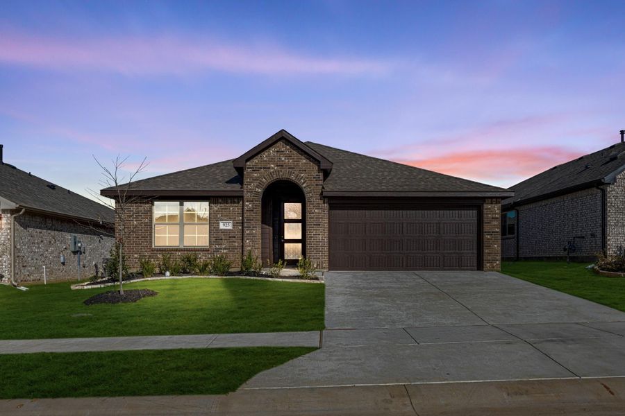 Single-story brick home with arched entry, two-car garage, and manicured front lawn at dusk Single-story brick home with arched entry, two-car garage, and manicured front lawn at dusk