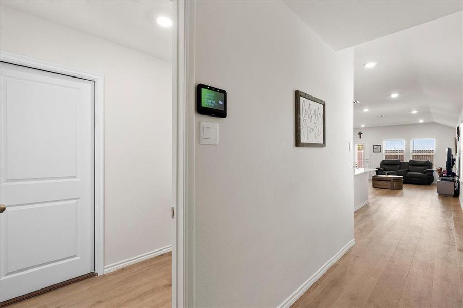 Corridor featuring recessed lighting, light wood-style floors, and lofted ceiling Corridor featuring recessed lighting, light wood-style floors, and lofted ceiling