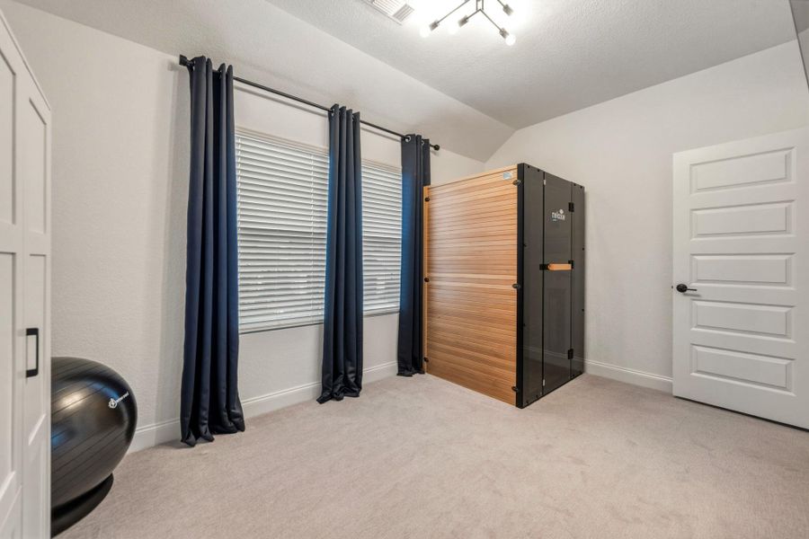 Carpeted room featuring a decorative lighting fixture