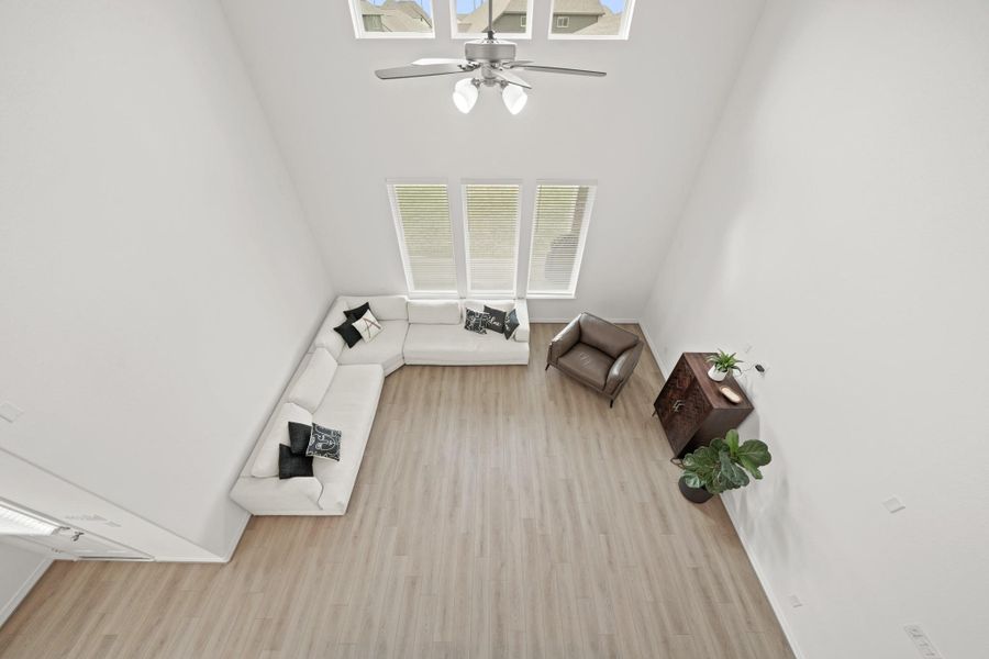 This spacious living area features high ceilings, large windows for natural light, and neutral flooring.