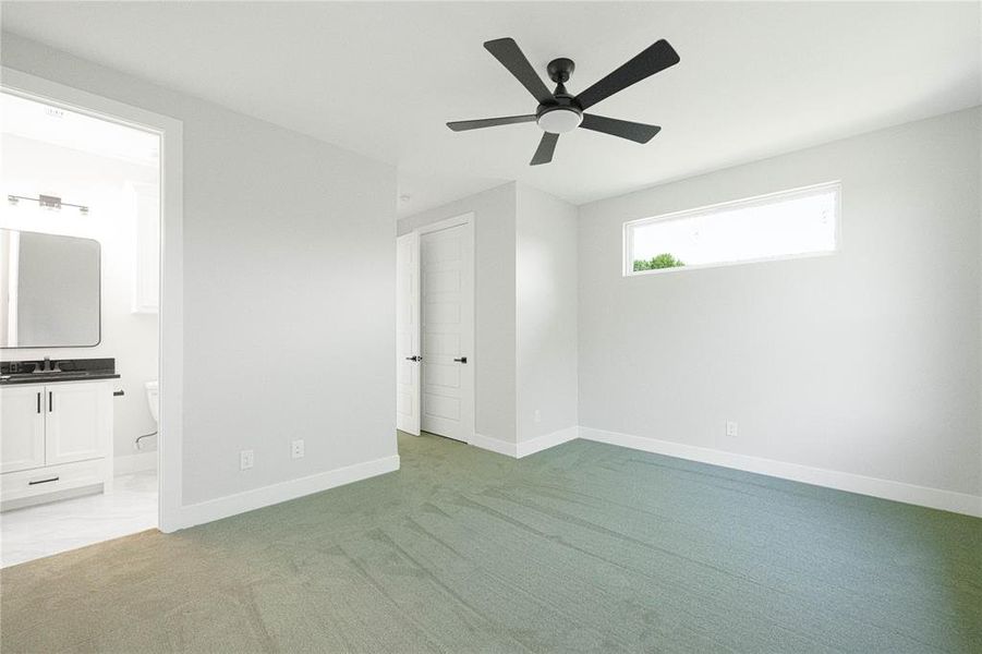 Unfurnished bedroom featuring light colored carpet, baseboards, ensuite bath, and a sink Unfurnished bedroom featuring light colored carpet, baseboards, ensuite bath, and a sink