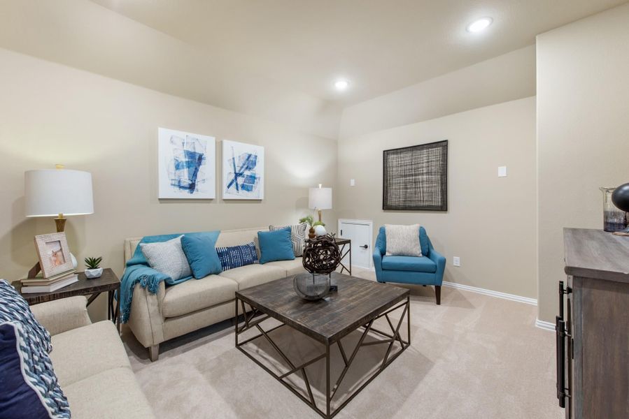 Living room with beige sofa, teal accent pillows, wood coffee table, and neutral carpet Living room with beige sofa, teal accent pillows, wood coffee table, and neutral carpet