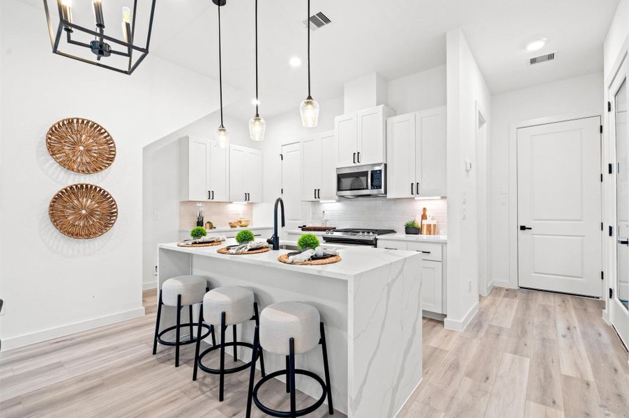 Quartz waterfall island, stainless steel appliances, and modern shaker cabinetry throughout the kitchen Quartz waterfall island, stainless steel appliances, and modern shaker cabinetry throughout the kitchen
