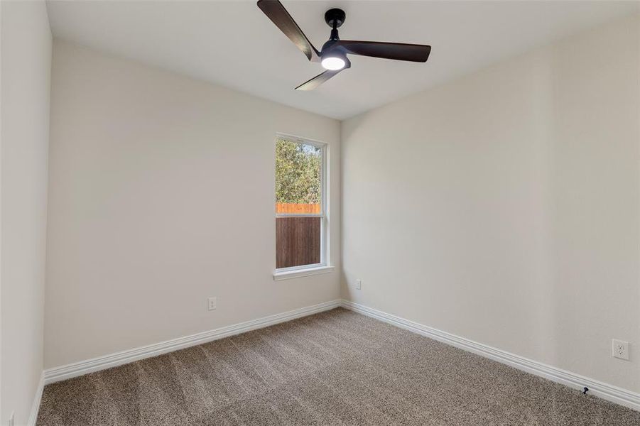 Carpeted spare room with ceiling fan