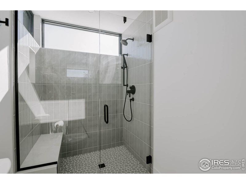 Upper level, walk-in euro glass shower enclosure with waterfall top bench. Understated elegance throughout this home.