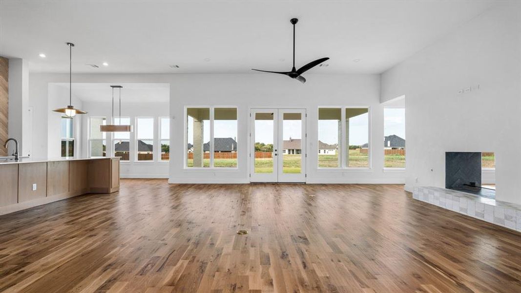 Unfurnished living room with ceiling fan, dark hardwood / wood-style floors, sink, and a healthy amount of sunlight