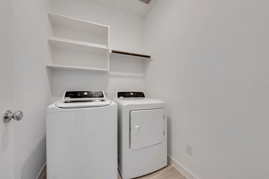 Washroom with independent washer and dryer and light wood-type flooring Washroom with independent washer and dryer and light wood-type flooring