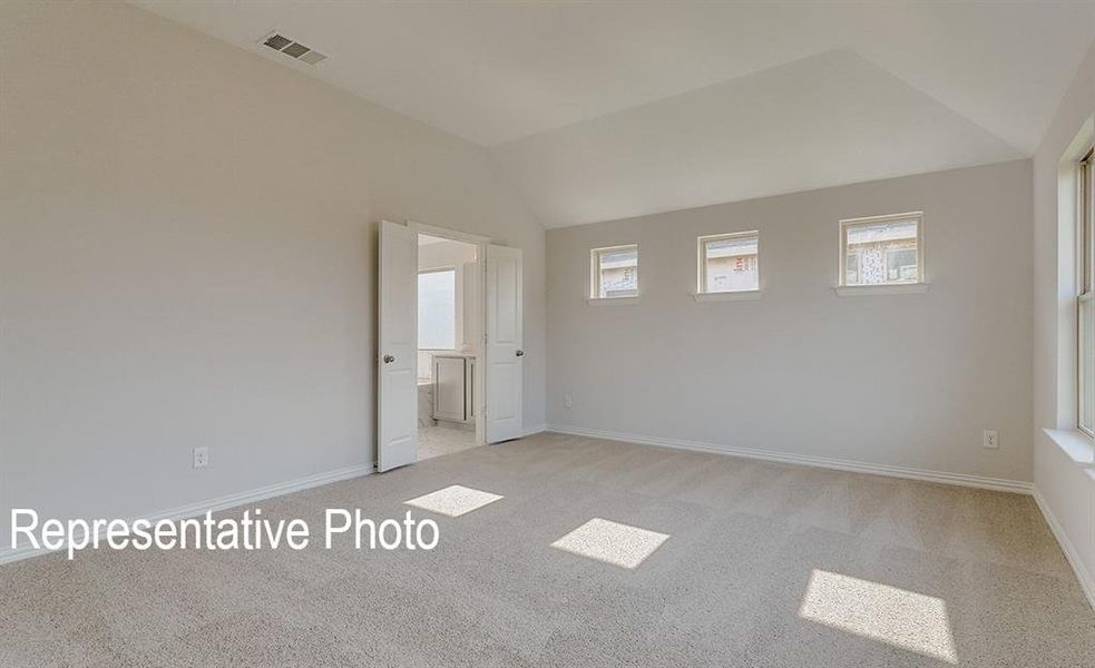 Carpeted spare room with vaulted ceiling