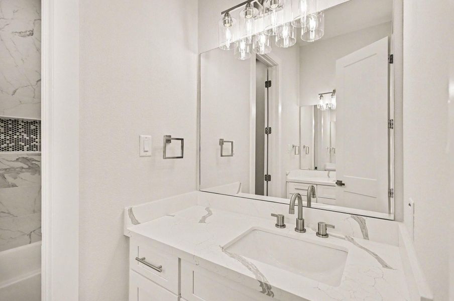 Elegant guest bath featuring modern finishes and designer lighting.