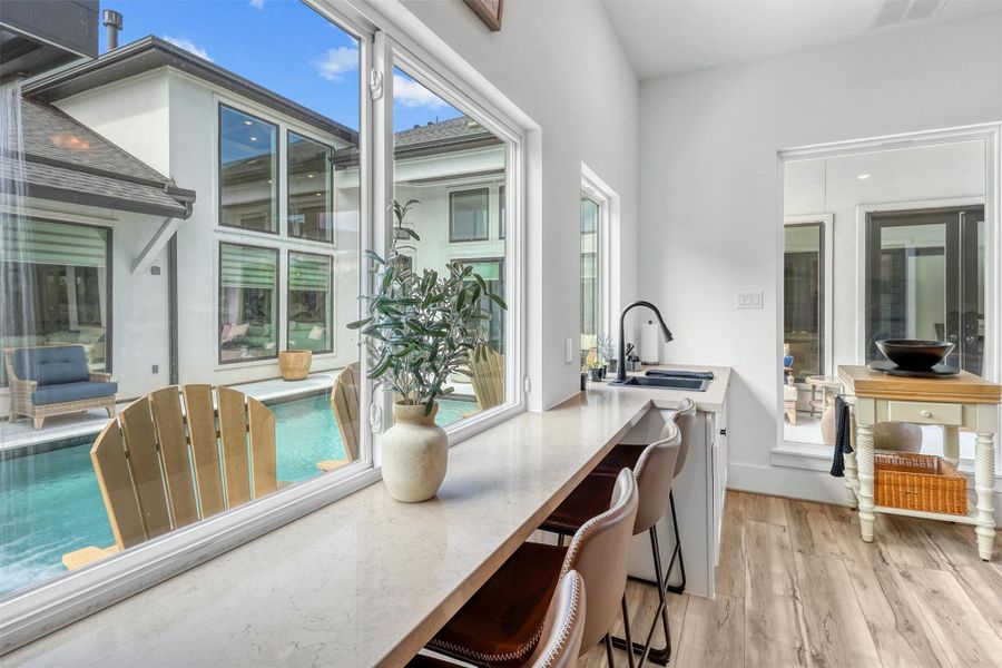 Easily transition from day to night, this breakfast bar turns into a pool bar by sliding the window over and opening up to the pool!