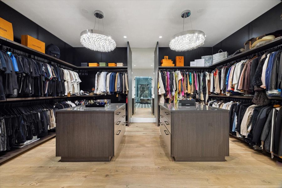This luxury elegant custom designed primary dressing room is the epitome of high-end millwork showcasing a grand scale of double islands providing an abundance of storage