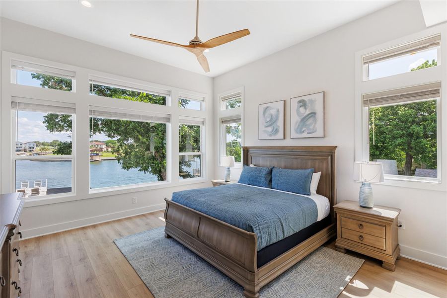 Primary Bedroom featuring light wood finished floors, a ceiling fan, a water view, and recessed lighting. Primary Bedroom featuring light wood finished floors, a ceiling fan, a water view, and recessed lighting.