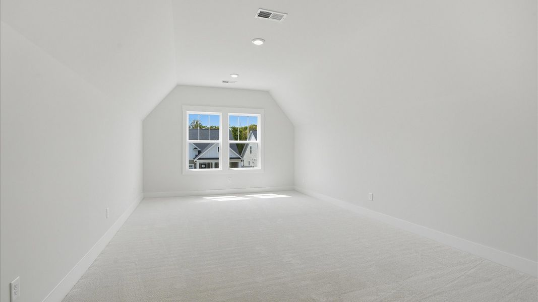 Functional and tasteful upstairs bonus room with plush carpet and vibrant natural light at Pelham Crossing