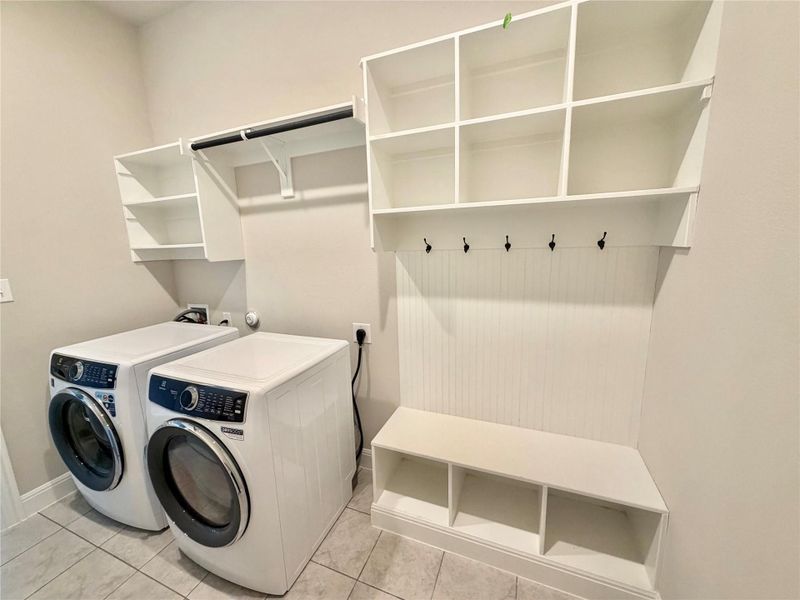 Laundry room with separate washer and dryer and light tile patterned floors Laundry room with separate washer and dryer and light tile patterned floors