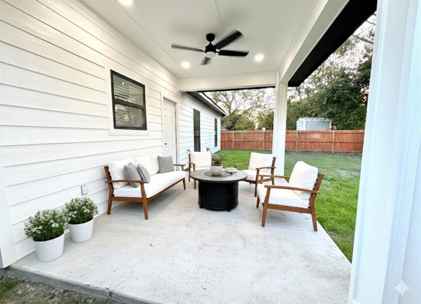Fenced backyard with a ceiling fan, an outdoor living space with a fire pit, and a patio Fenced backyard with a ceiling fan, an outdoor living space with a fire pit, and a patio