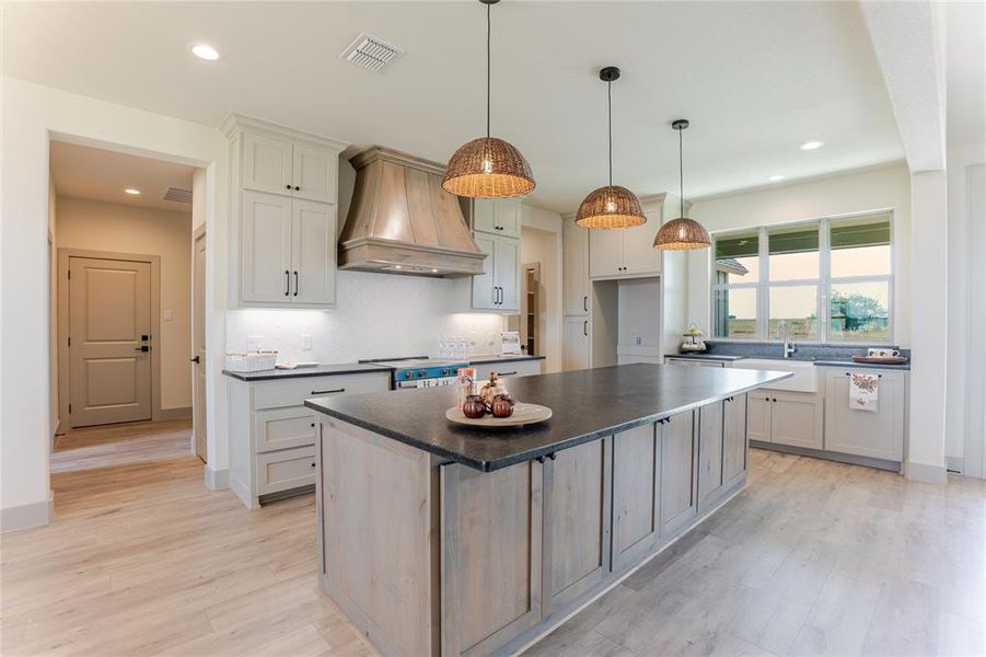 Right of the kitchen is the entry from the garage with laundry and powder room. Right of the kitchen is the entry from the garage with laundry and powder room.