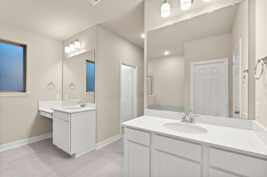 The en-suite bathroom offers a spa-like atmosphere with its elegant design, high end finishes, and tasteful lighting, creating a retreat within your own home.