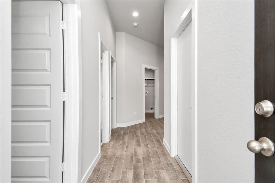 Indulge in luxury as you step into the threshold of this breathtaking home. The grand entrance beckons with its soaring ceilings, adorned with elegant wood-look tile flooring featuring sleek oversized baseboards. Sample photo of similar plan. Actual colors and selections may vary.