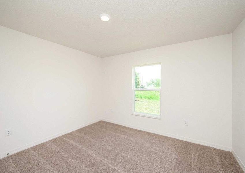 Spare bedroom with a single hung window, light brown carpet and a ceiling light fixture in the Caladesi floor plan.