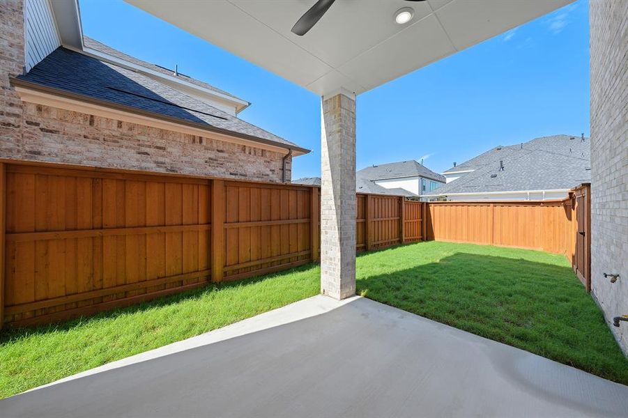 Fenced backyard with a patio and ceiling fan